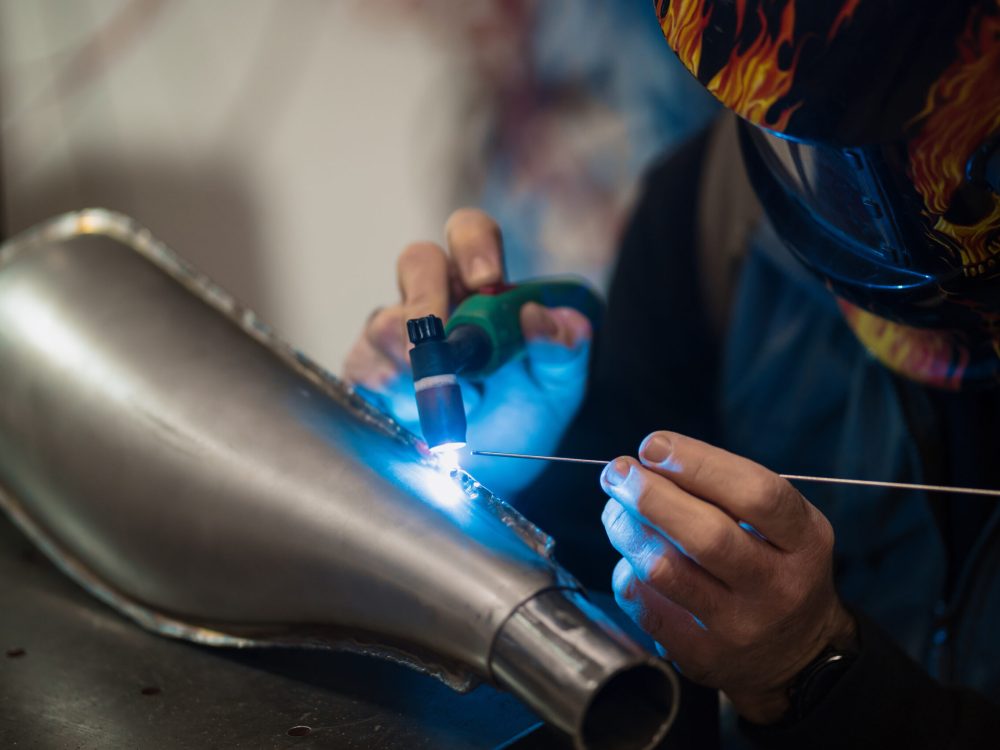 Repairman repair motorcycle, maintenance in garage. Mechanic fixing bike in a modern shop