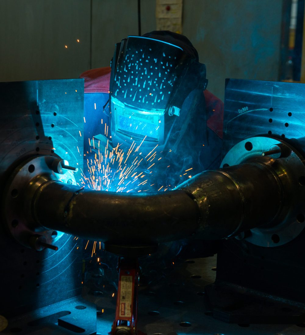 Professional welder working with steel structures - Industrial Worker at the factory